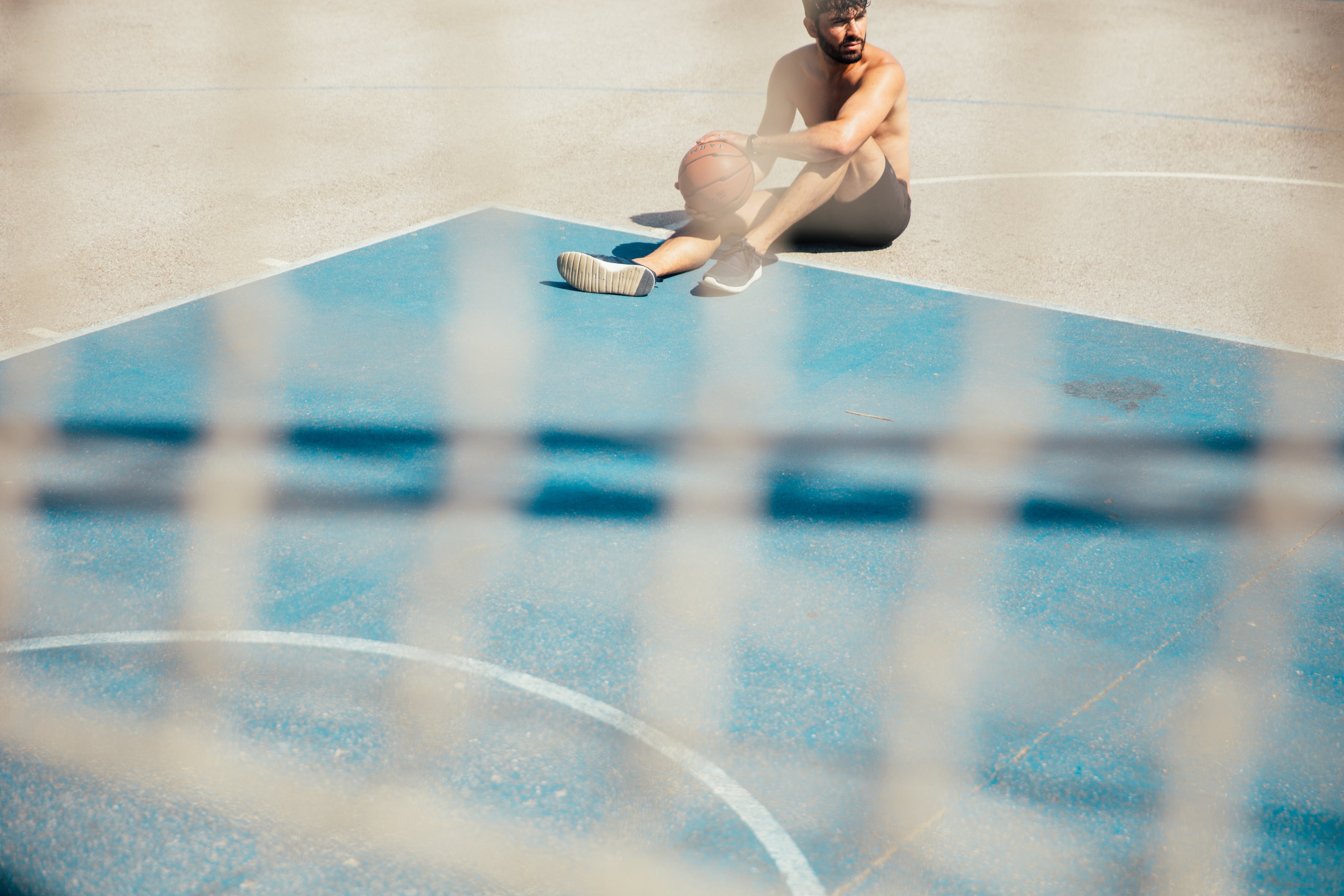 files/Man-Sitting-On-Basketball-Court.jpg